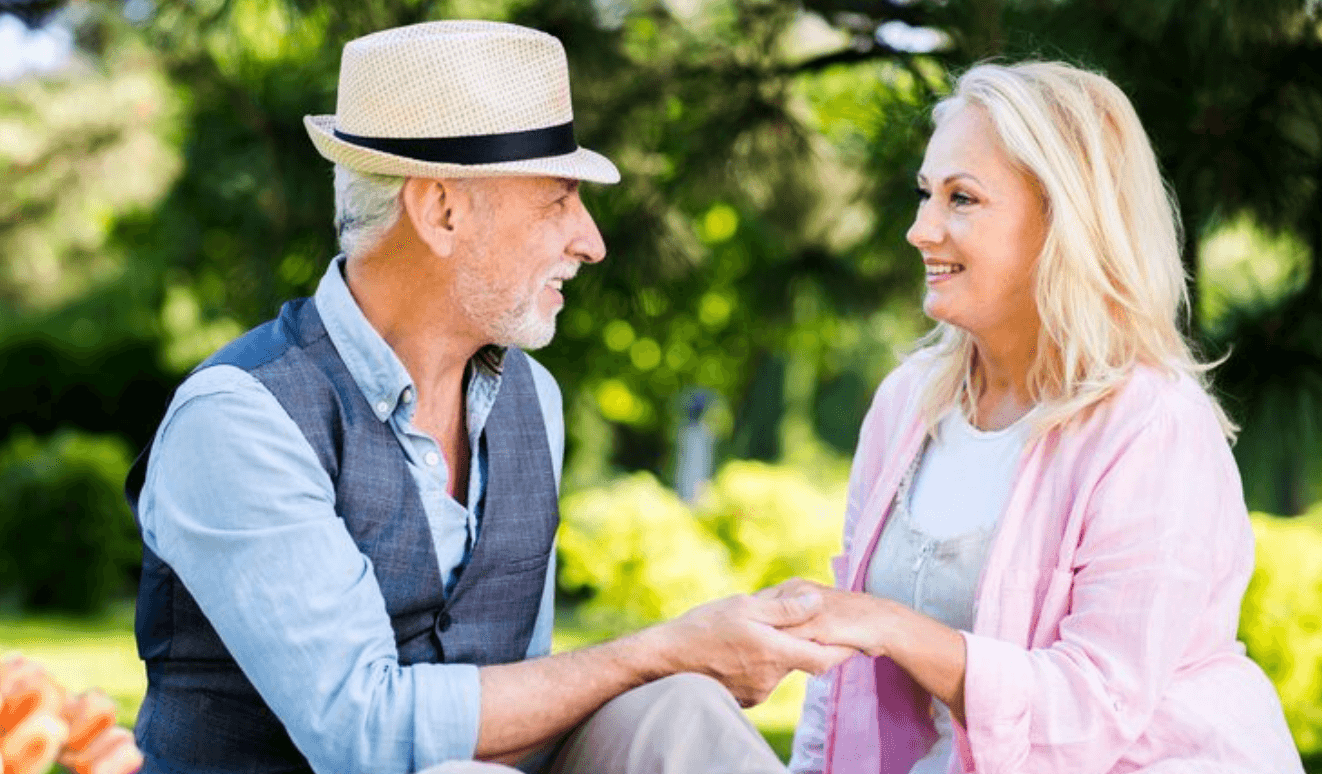 Two older adults talking together in a park