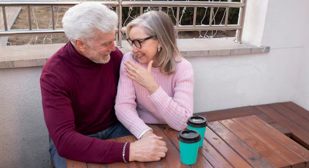 Older couple laughing together at a table