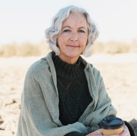 Older woman sitting outdoors with a drink